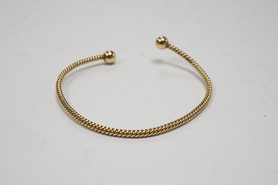 A modern 9ct gold open work bangle, with spherical terminals, 8.4 grams. Condition - fair